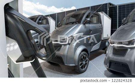Electric vehicles charging station on a background of a small city delivery trucks Electric vehicles charging station on a background of a small city delivery trucks 122824328