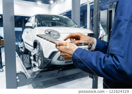 Serviceman with digital tablet on the background of the car in the car service 122824329