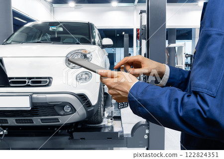 Serviceman with digital tablet on the background of the car in the car service 122824351