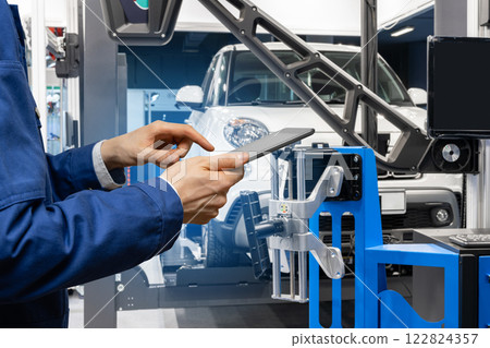 Serviceman with digital tablet on the background of the truck in the car service. 122824357