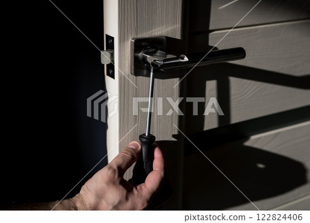 Worker using screwdriver on door lock Worker using screwdriver on door lock 122824406