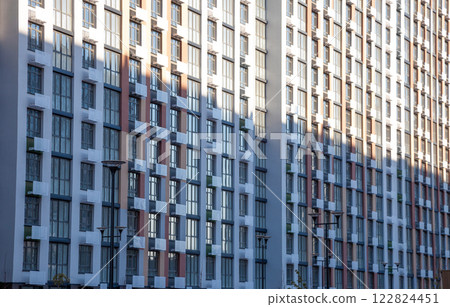 Pattern from the windows of a new multi-storey building. Window in modern architecture. Apartment house, new building. 122824451