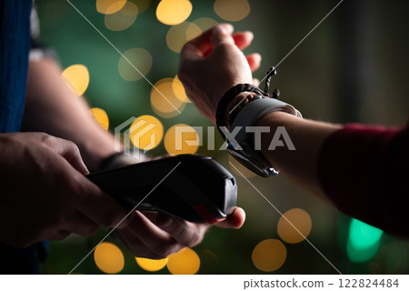Girl Paying Bill With Watch Using Wireless Pos Terminal During Christmas, Waiter Processing Payment Girl Paying Bill With Watch Using Wireless Pos Terminal During Christmas, Waiter Processing Payment 122824484