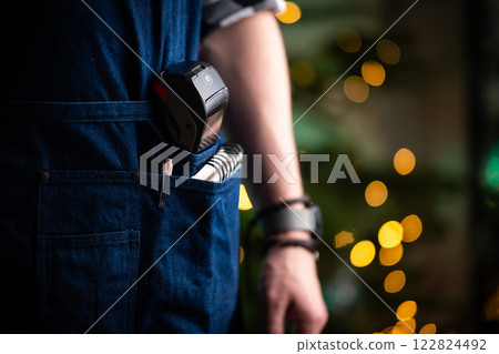 Waiter With Wireless Terminal In Apron Pocket At Christmas Background 122824492