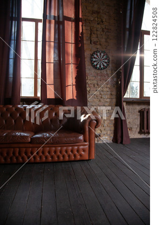 Windows at empty Library room with a brick wall. Leather sofa in a vintage style. The furniture in the room. Dark brown interior 122824508