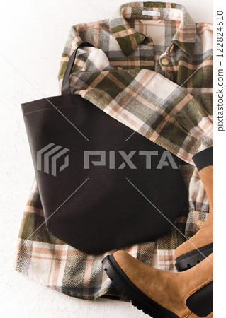 Black eco shopping bag with place for text. Bag mock up template top view. Wardrobe with shirt and boots. Clothes and accessories. Black eco shopping bag with place for text. Bag mock up template top view. Wardrobe with shirt and boots. Clothes and accessories. 122824510