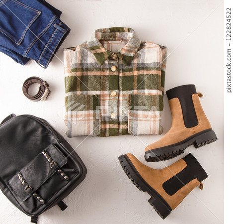 Set of clothes. Checked shirt, jeans, beige boots, leather backpack. Shoes and wardrobe. Women's modern style. 122824522