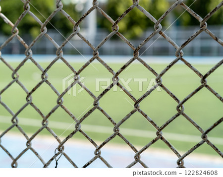 Rusty fence surrounding sports field outdoor area urban environment close-up texture detail 122824608
