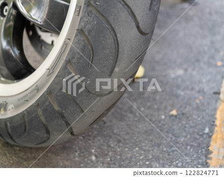 Motorcycle tire close-up urban street industrial setting ground level detail focus 122824771