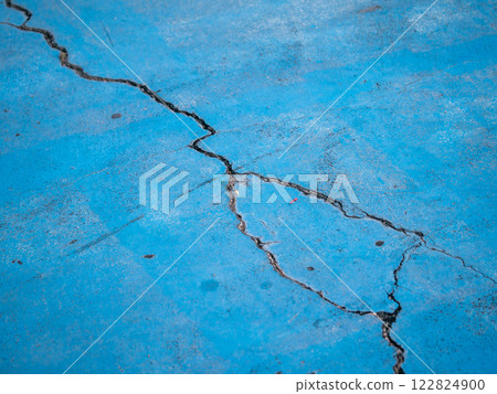 Cracked blue surface urban setting close-up industrial environment ground level texture analysis 122824900
