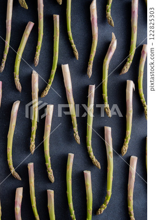 Green asparagus pattern on background. Vegetable sprouts stems 122825303