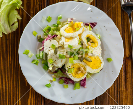 Appetizing egg dish in a plate on a wooden table 122825460