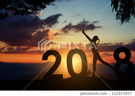 Silhouette young woman jumping to 2018 new year Silhouette young woman jumping to 2018 new year 122825857