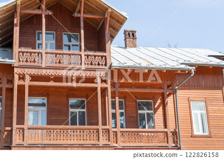 Wooden balcony of a wood house. Exterior facade. 122826158