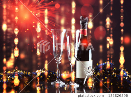 Christmas and New Year. Festive decorations, bottle of champagne and pair of flute on the dark background. Happy New Year and Christmas. Bokeh light soft effect Christmas and New Year. Festive decorations, bottle of champagne and pair of flute on the dark background. Happy New Year and Christmas. Bokeh light soft effect 122826296