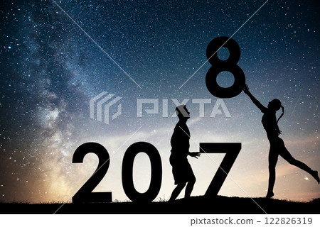 Silhouette young girl and guy. Happy 2018 new year. Background of the Milky Way galaxy on a bright star dark sky tone. Concept change year 2017 to 2018 122826319