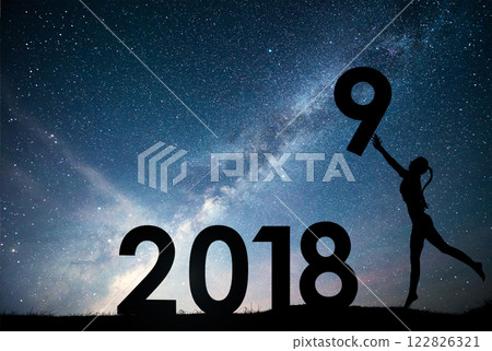 Silhouette young girl. Happy 2018 new year. Background of the Milky Way galaxy on a bright star dark sky tone. Concept change year 2017 to 2018 Silhouette young girl. Happy 2018 new year. Background of the Milky Way galaxy on a bright star dark sky tone. Concept change year 2017 to 2018 122826321
