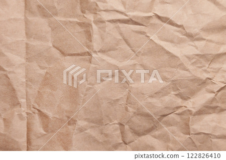 Wrinkled recycled kraft paper surface with creases and fold. Eco-friendly textured crumpled brown background for packaging. Close-up Wrinkled recycled kraft paper surface with creases and fold. Eco-friendly textured crumpled brown background for packaging. Close-up 122826410
