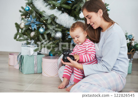 happy family mother and child daughter on Christmas morning at the Christmas tree with gifts 122826545