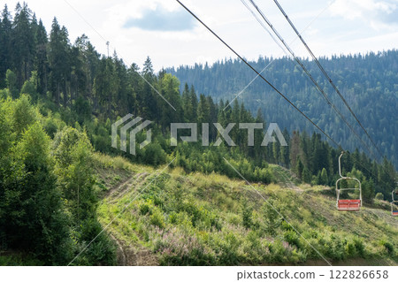 Ski lift in green forest. Cableway in Mountains. Summer nature. Ski lift in green forest. Cableway in Mountains. Summer nature. 122826658