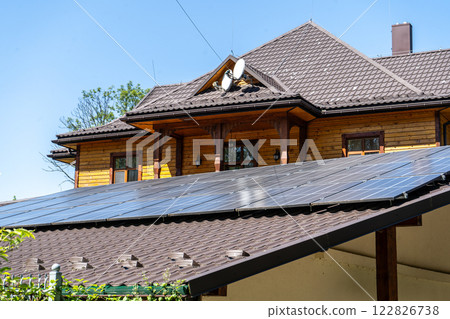 Solar panels on the roof of a residential building wooden house in a village. Solar panels on the roof of a residential building wooden house in a village. 122826738