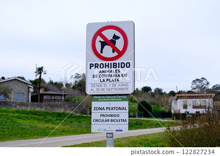 A sign that says Prohibido Animal en la Compania is on a pole. A sign that says Prohibido Animal en la Compania is on a pole. 122827234