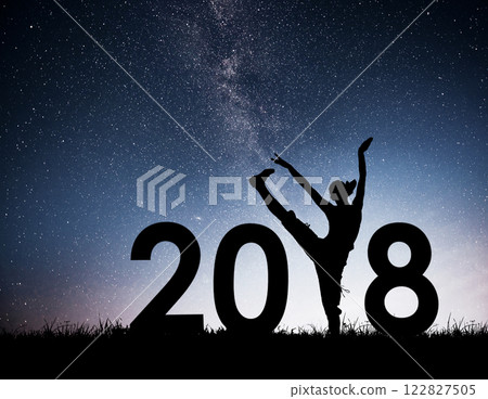 Silhouette of a young girl doing fitness. 2018 new year background of the Milky Way galaxy on a bright star dark sky tone 122827505