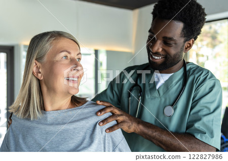 African american male doctor working on correction of female patients posture 122827986