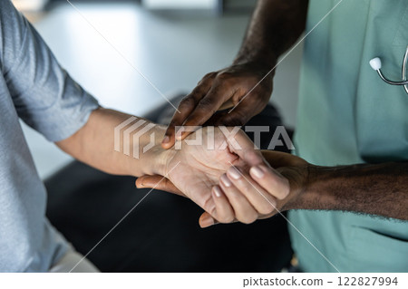 Doctor checking the pulse of a patient in the clinic Doctor checking the pulse of a patient in the clinic 122827994