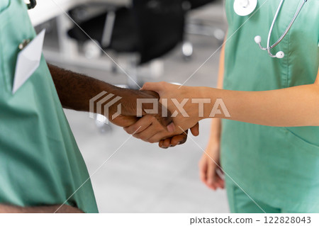 Unrecognizable diverse professional doctors shaking hands at medical office 122828043
