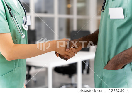 Unrecognizable female doctor shaking hands with multiracial colleague in hospital Unrecognizable female doctor shaking hands with multiracial colleague in hospital 122828044