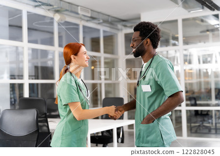 Female doctor shaking hands with multiracial colleague in hospital 122828045