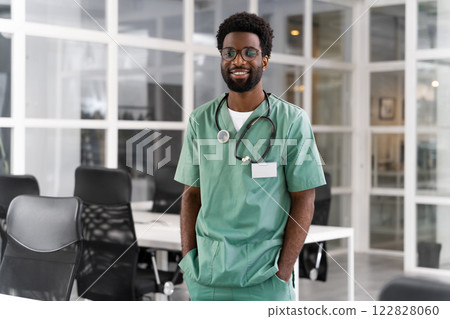 Happy African American male doctor wearing uniform and stethoscope looking at camera 122828060