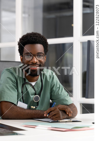 Confident male doctor with stethoscope in uniform providing therapy and treatment 122828073