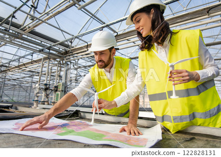 Two engineers discussing the construction plan and looking involved 122828131