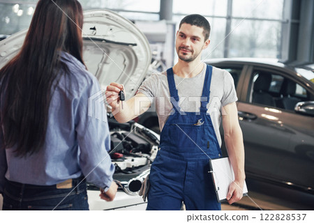 cropped view of mechanic giving car keys to female client cropped view of mechanic giving car keys to female client 122828537