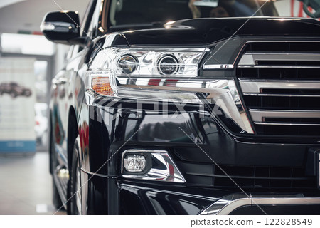 The headlights and the hood of a black luxury car 122828549