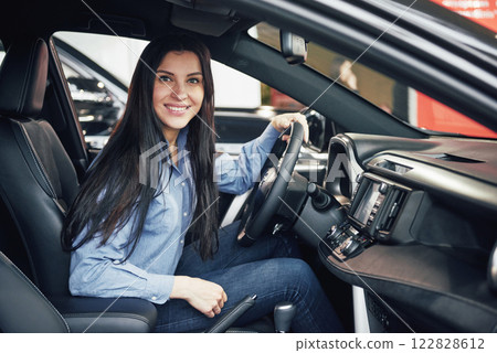 auto business, car sale, consumerism and people concept - happy woman taking car key from dealer in auto show or salon 122828612