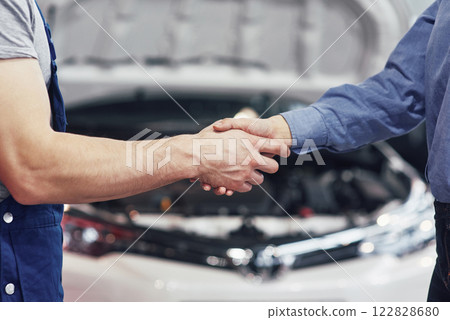 husband car mechanic and woman customer make an agreement on the repair of the car 122828680