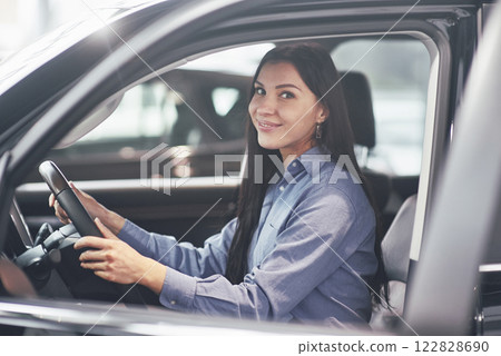 auto business, car sale, consumerism and people concept - happy woman taking car key from dealer in auto show or salon 122828690