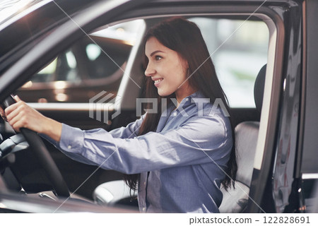 auto business, car sale, consumerism and people concept - happy woman taking car key from dealer in auto show or salon auto business, car sale, consumerism and people concept - happy woman taking car key from dealer in auto show or salon 122828691
