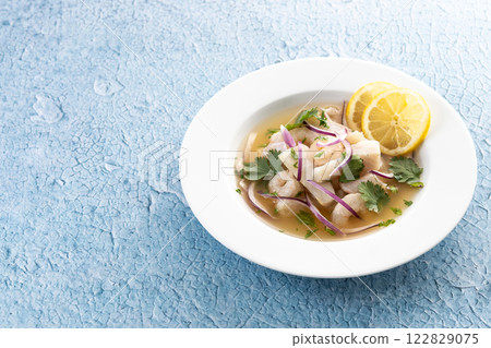 Traditional Peruvian ceviche sea bass fillet on blue background 122829075
