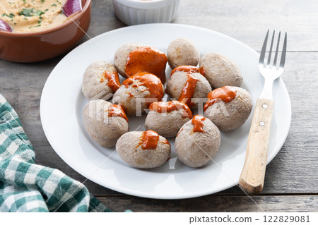 Papas arrugadas with mojo and gofio escaldado on wooden table. Traditional Canary Islands food. 122829081