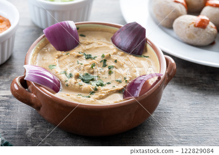 Papas arrugadas with mojo and gofio escaldado on wooden table. Traditional Canary Islands food. Papas arrugadas with mojo and gofio escaldado on wooden table. Traditional Canary Islands food. 122829084