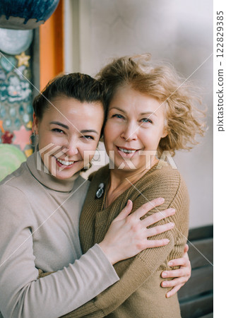 Mother and daughter hugging and smiling, showing strong family bond Family connection, mother and daughter embracing with joy and affection 122829385