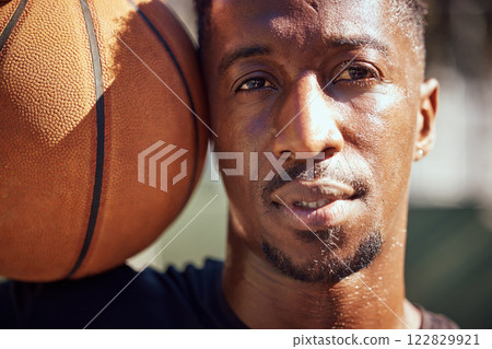 Basketball, sport and face with a man training with a ball for health, workout and fitness. Motivation, sports and exercise with a young male athlete playing a game or match on a court outside Basketball, sport and face with a man training with a ball for health, workout and fitness. Motivation, sports and exercise with a young male athlete playing a game or match on a court outside 122829921