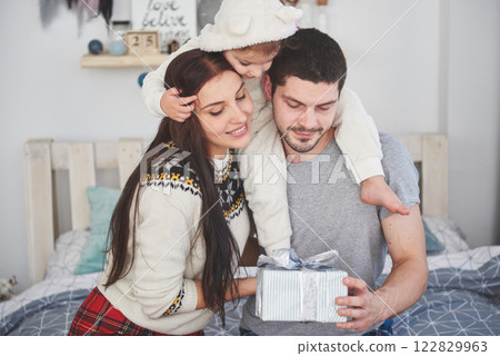 Happy family at christmas in morning opening gifts together near the fir tree. The concept of family happiness and well-being Happy family at christmas in morning opening gifts together near the fir tree. The concept of family happiness and well-being 122829963