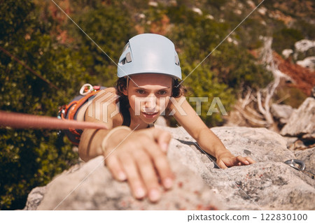 Sports, exercise and mountain climbing with a woman climber scaling or abseiling a cliff. Fitness, workout and training with a young female on a climb in the forest or woods in nature from above 122830100