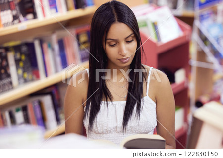 Student, book and woman reading in a library at university, college or school campus alone for education. Bookshelf, knowledge and scholarship girl student studying academic, smart and information Student, book and woman reading in a library at university, college or school campus alone for education. Bookshelf, knowledge and scholarship girl student studying academic, smart and information 122830150