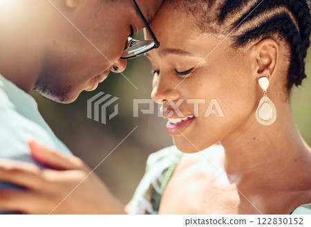 Happy couple hugging in nature while on a romantic date while bonding in the park. Closeup of care, love and young man and woman embracing each other in an outdoor garden during spring. 122830152